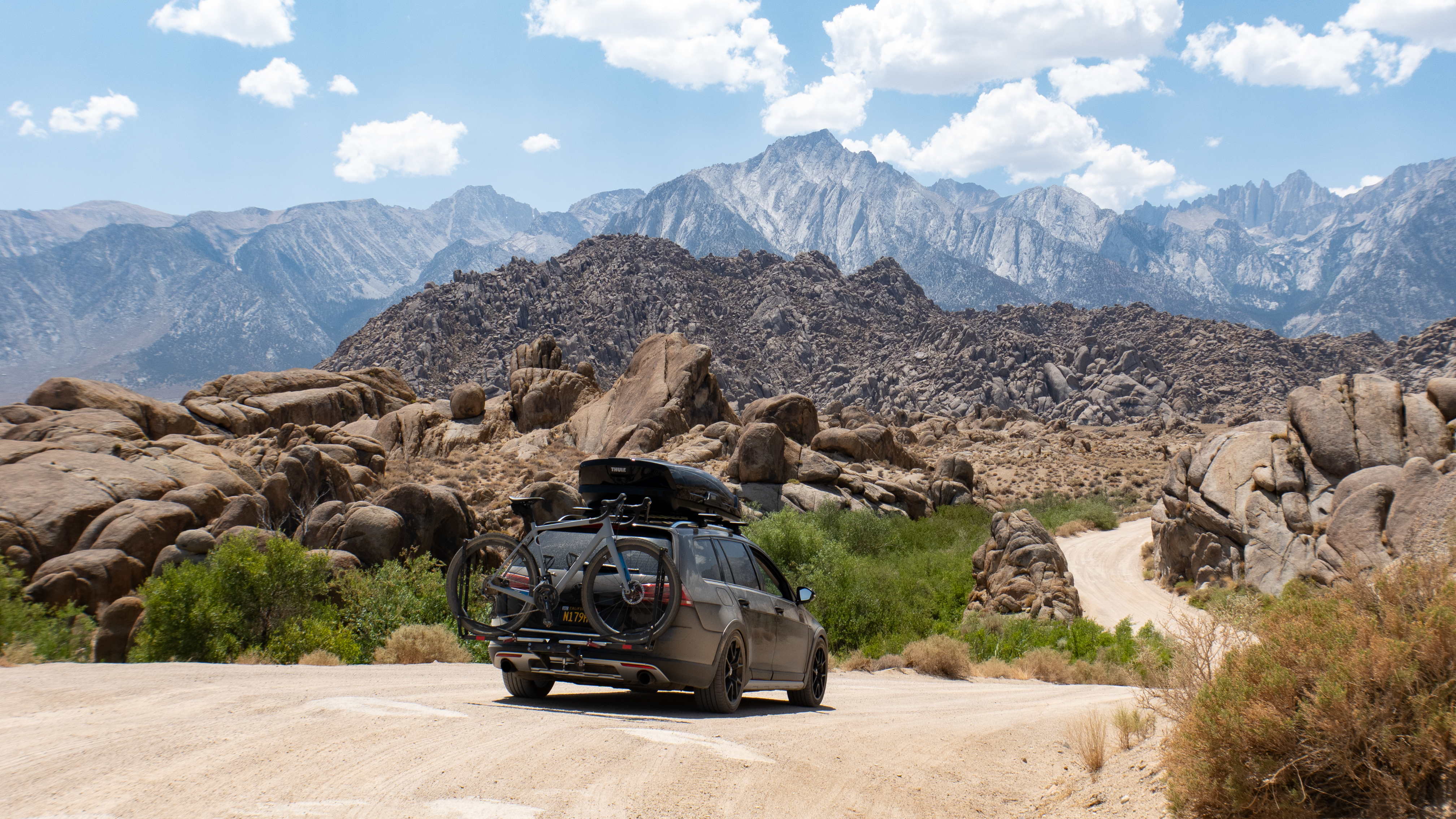 A wagon-grey estate car loaded with a bike below the Sierra crest